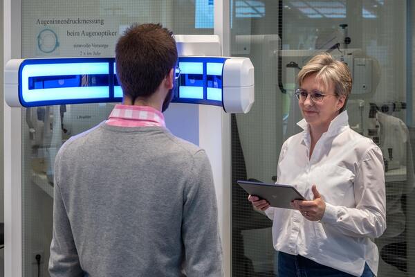 Ein Mann lässt beim Optiker eine moderne Augeninnendruckmessung zur Glaukomvorsorge durchführen.